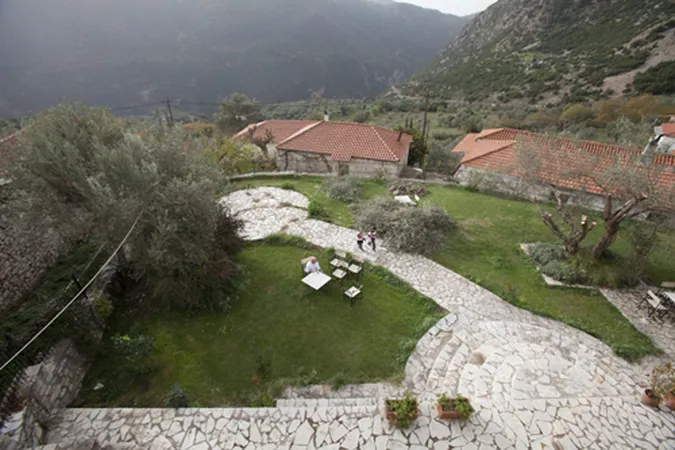 Η αυλή με το γρασίδι και τα πέτρινα μονοπάτια