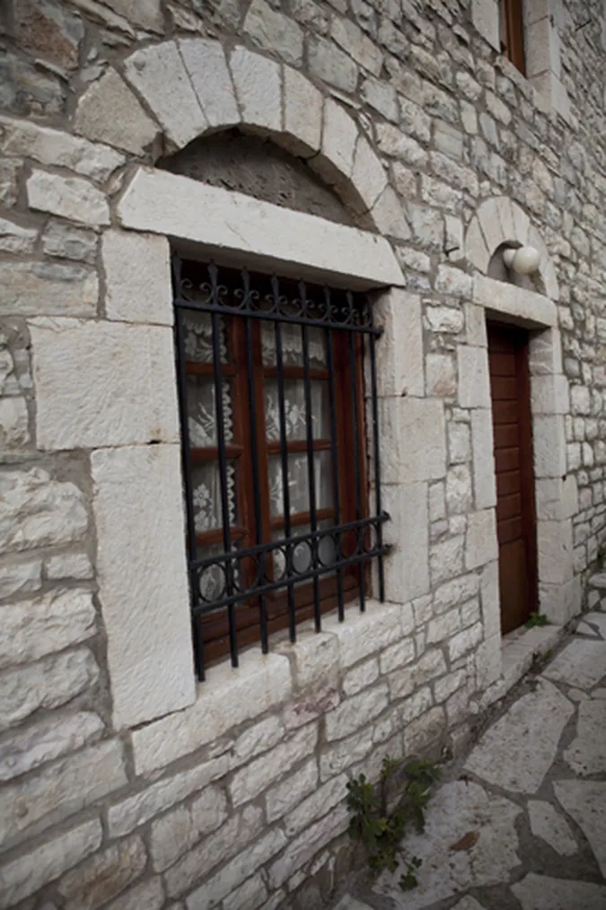 Παράθυρο σε πέτρινο τοίχο με λαξευτό πλαίσιο